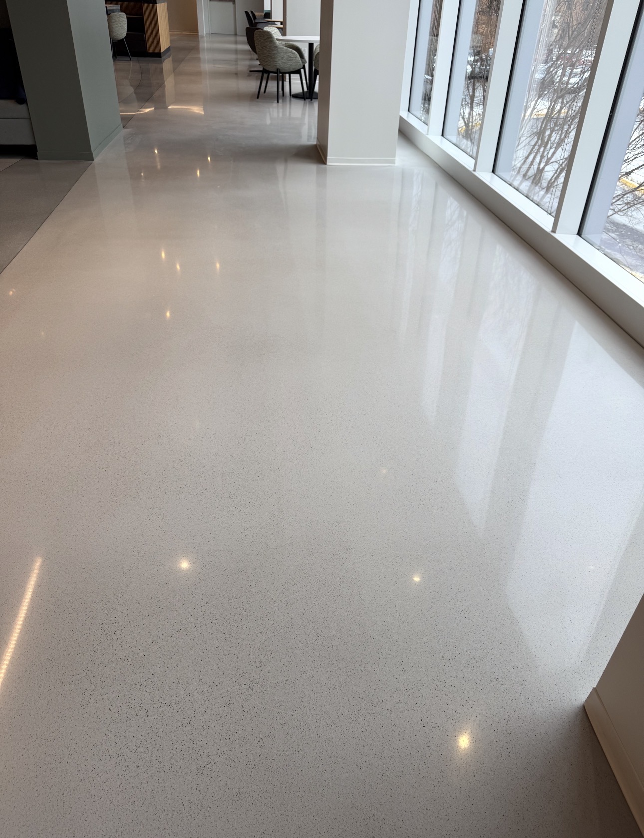 Light cream polished concrete corridor in an office reflecting window light