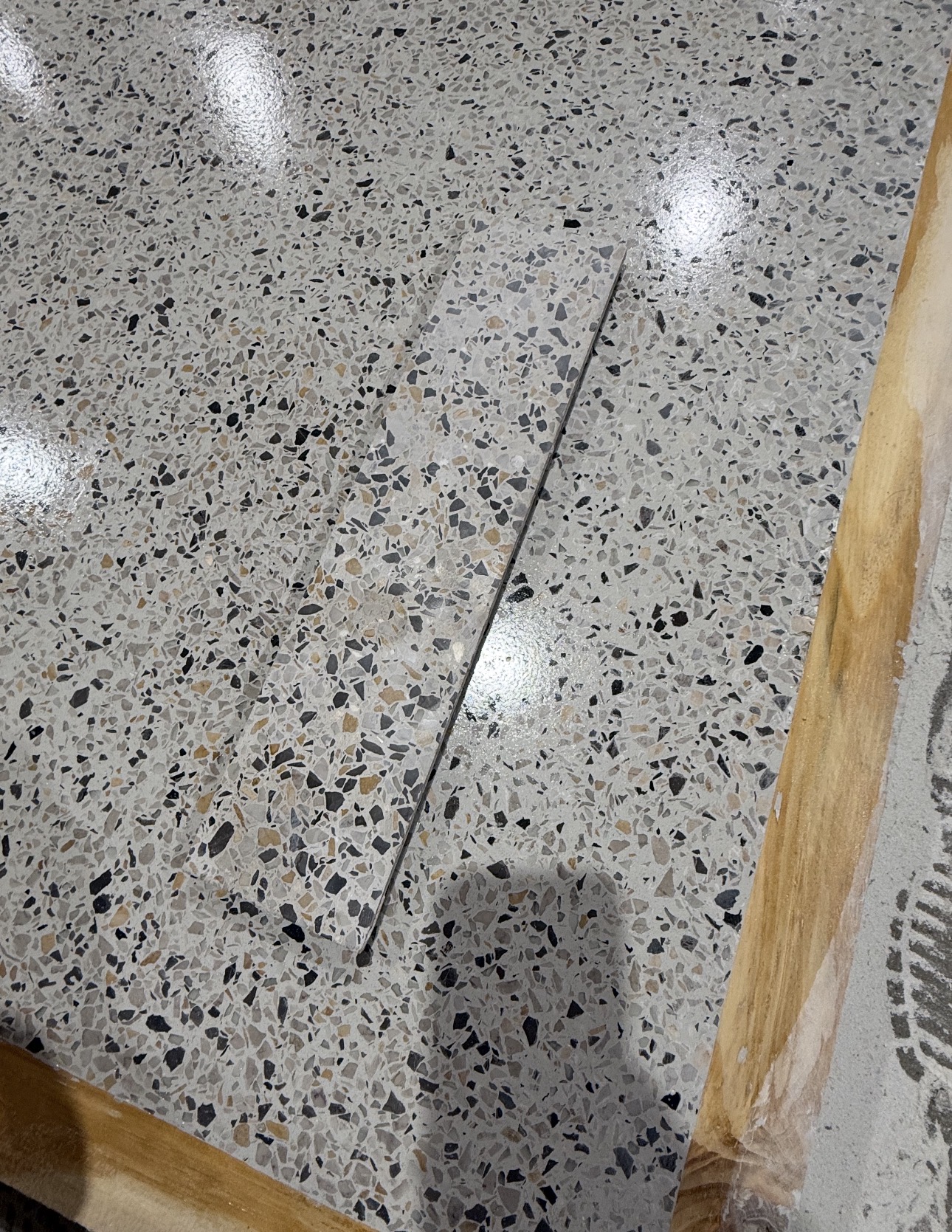 Terrazzo repair sample matched to an existing gray aggregate floor