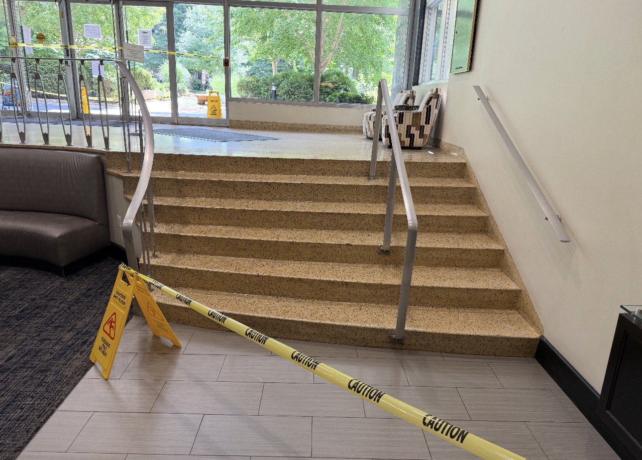 Restored tan terrazzo stairway and landing at a commercial entrance