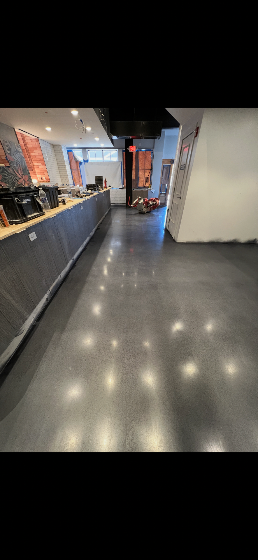 Polished gray coated floor running through a cafe service area