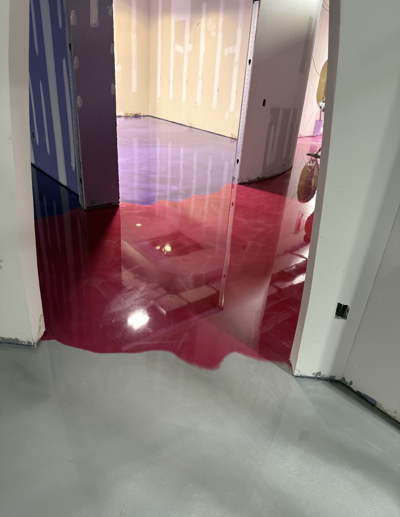 Glossy red and gray epoxy floor with curved color transitions
