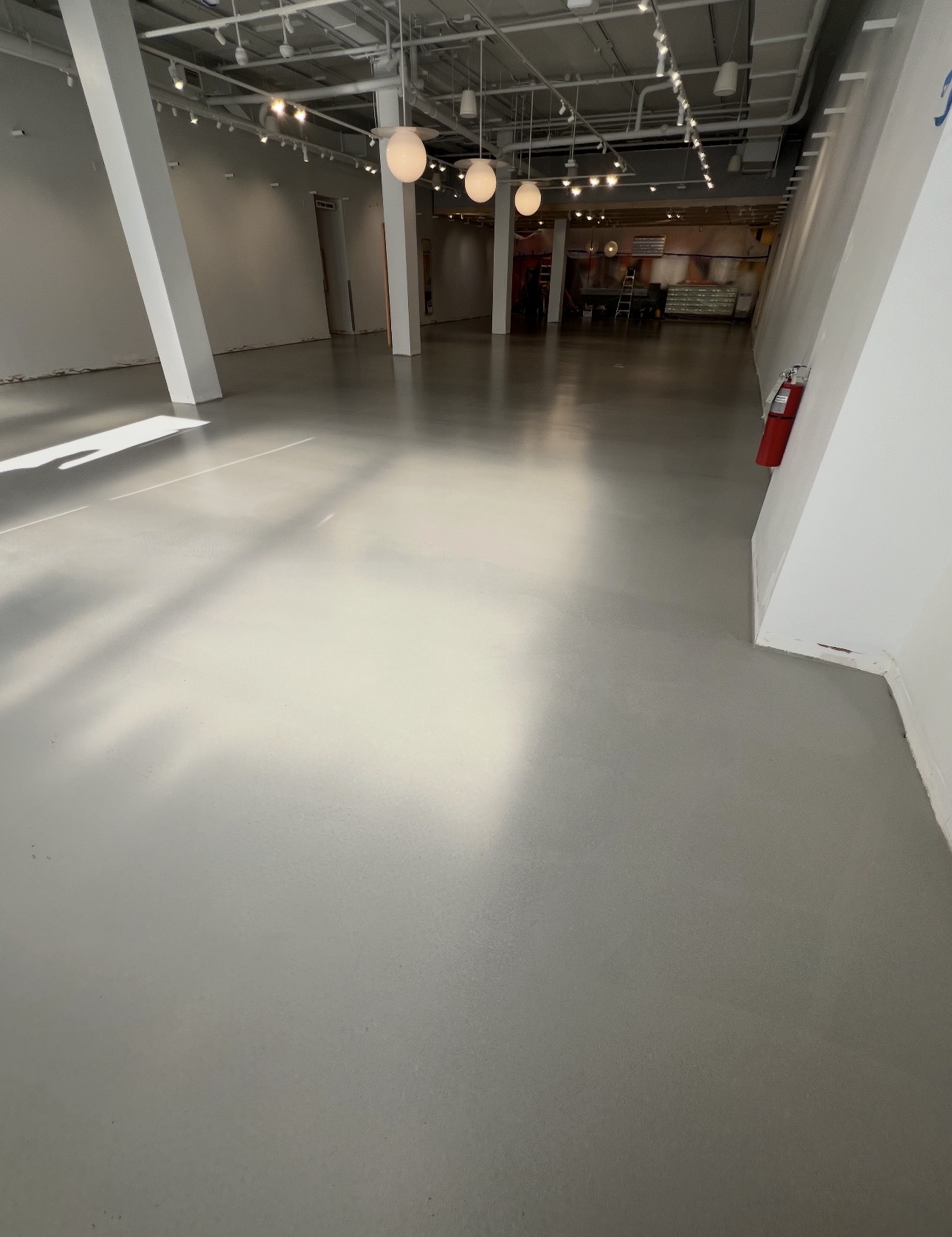 Gray industrial coating installed across an open retail space