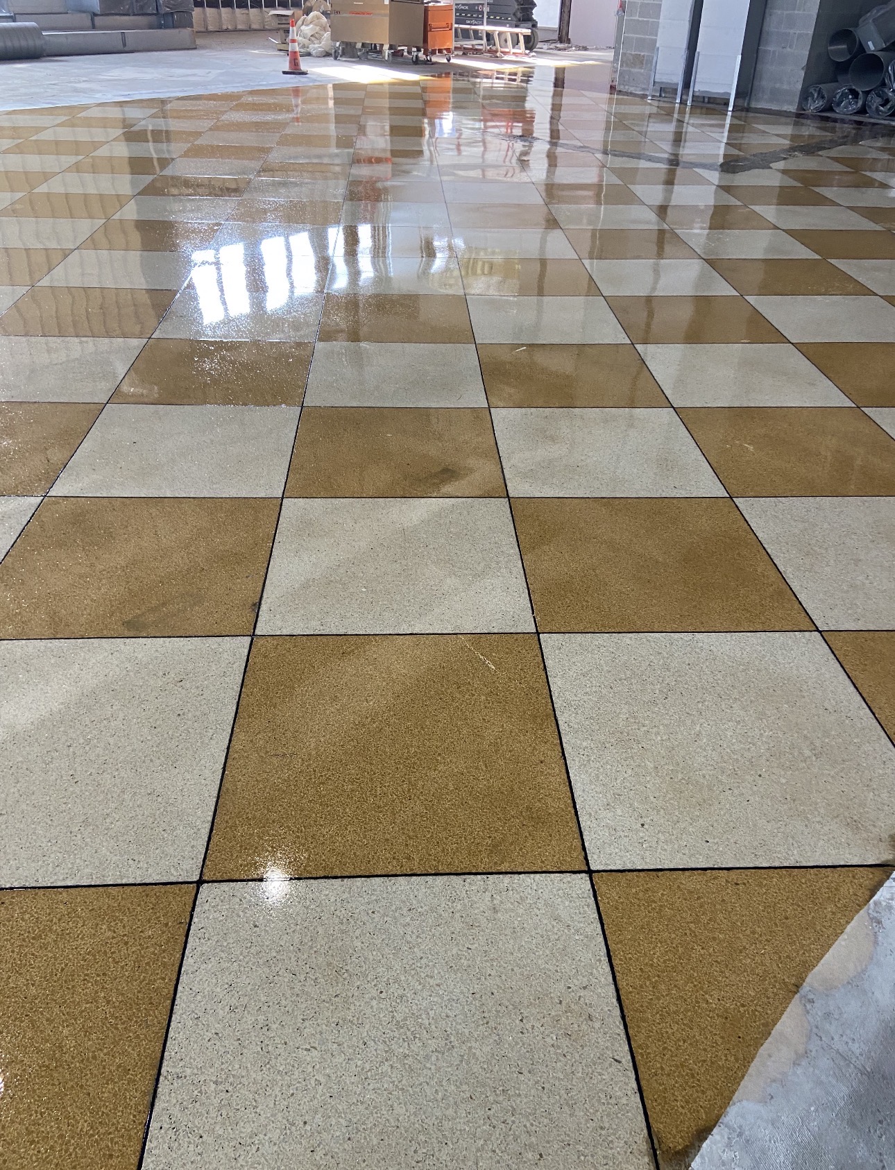 Restored tan and cream checkerboard terrazzo floor with high-gloss finish