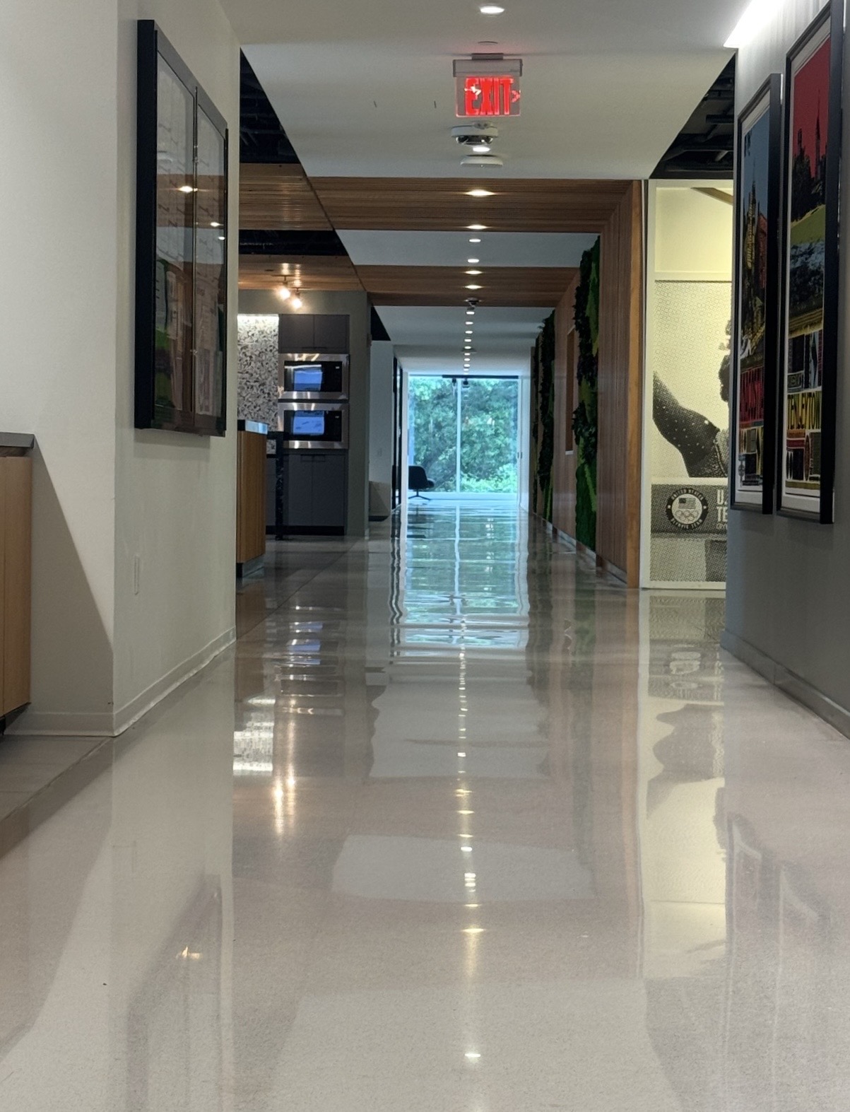 High-gloss light polished concrete corridor reflecting ceiling lights