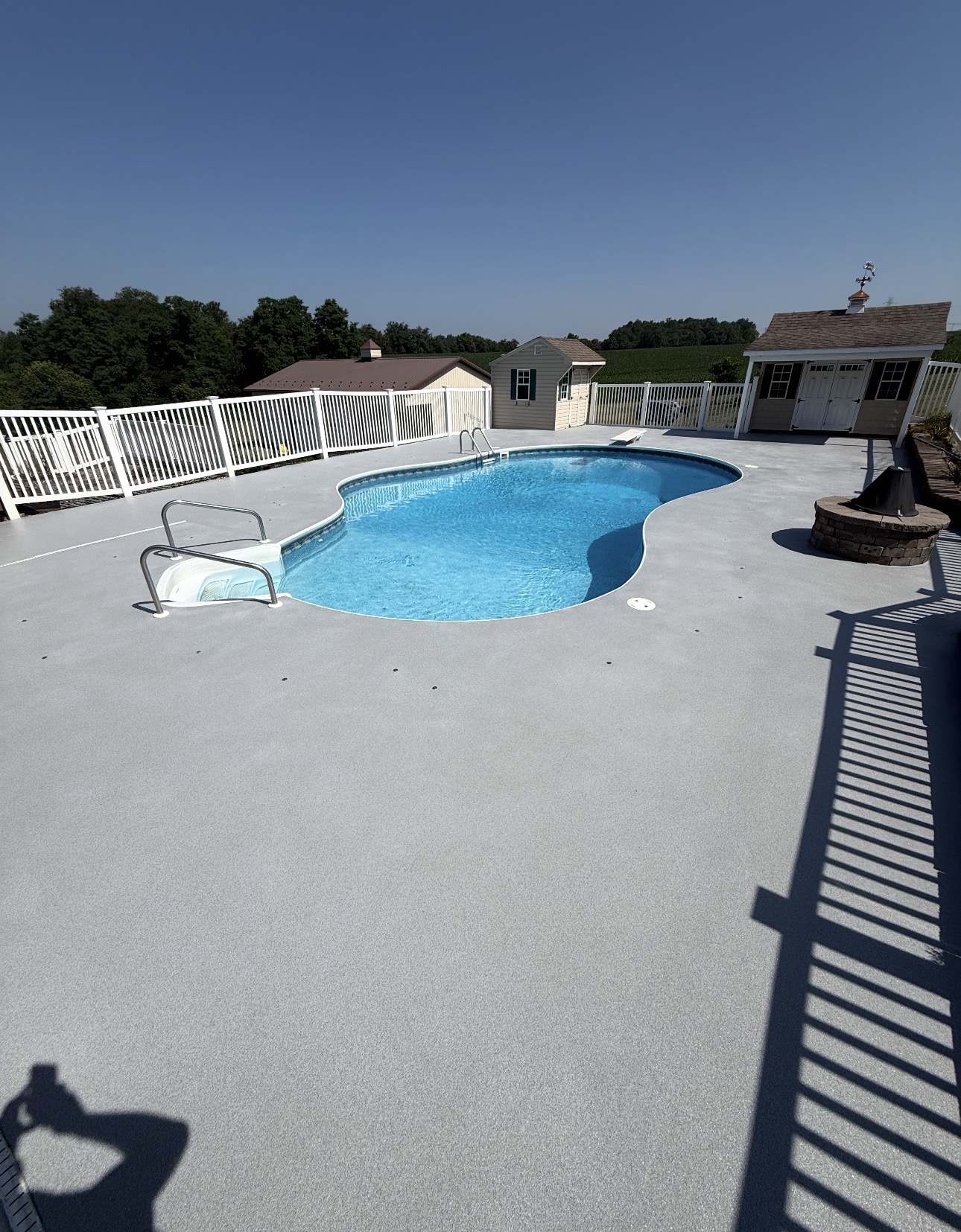 Light gray textured coating surrounding a residential swimming pool