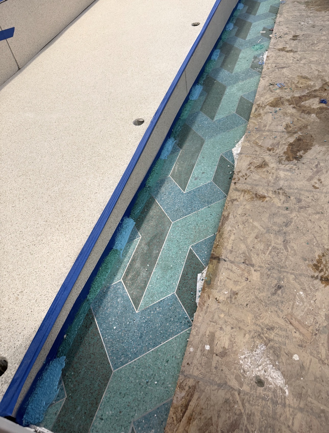 Geometric blue and teal terrazzo border during installation