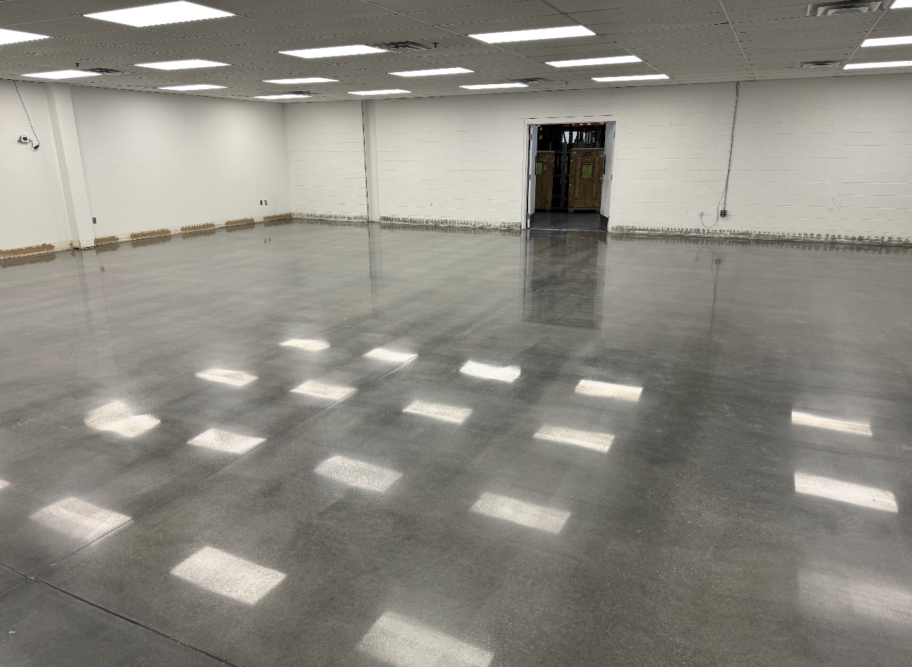 Gray polished concrete floor in a bright block-walled facility room